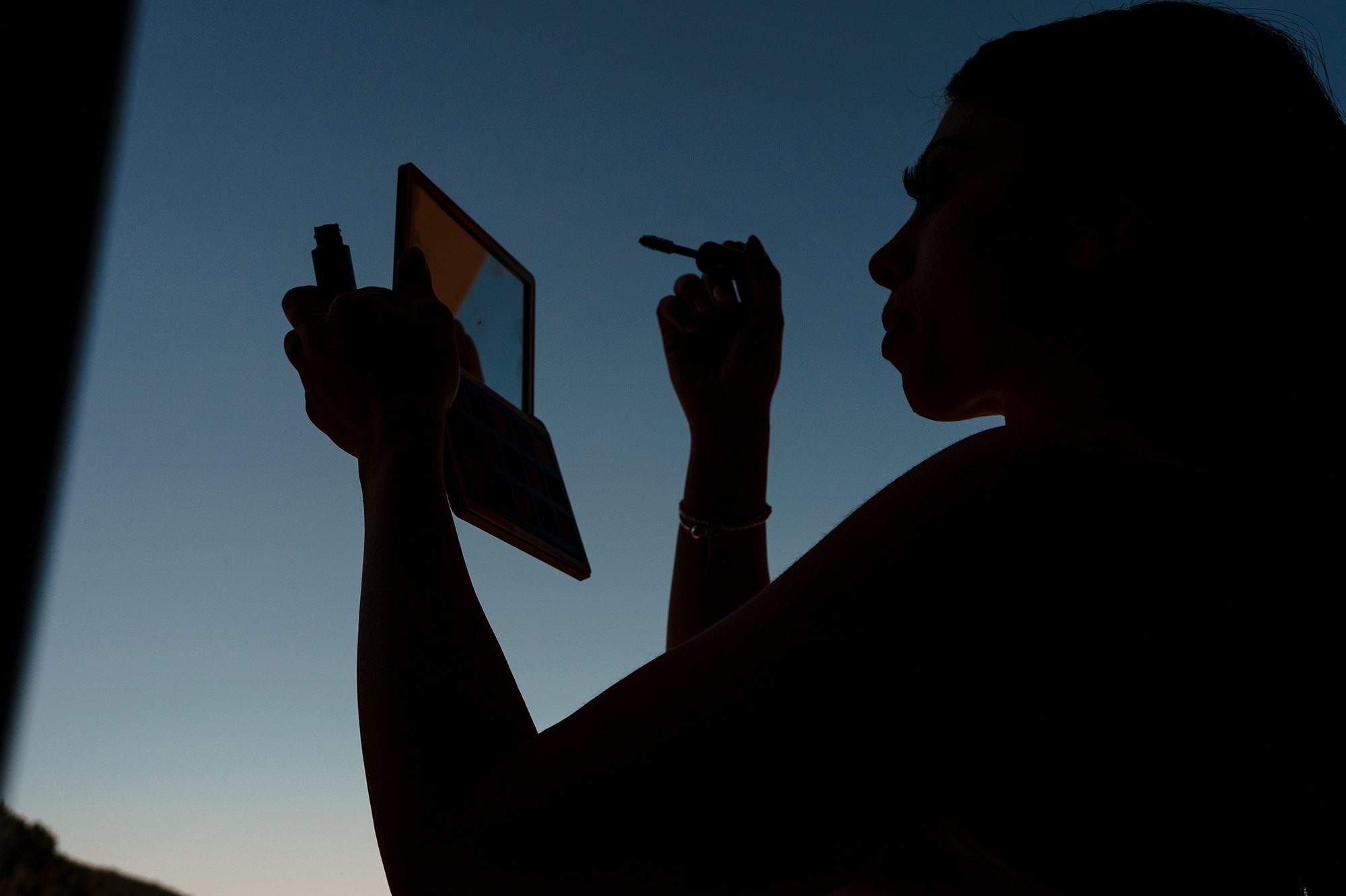 sicilian bride applying makeup for her wedding