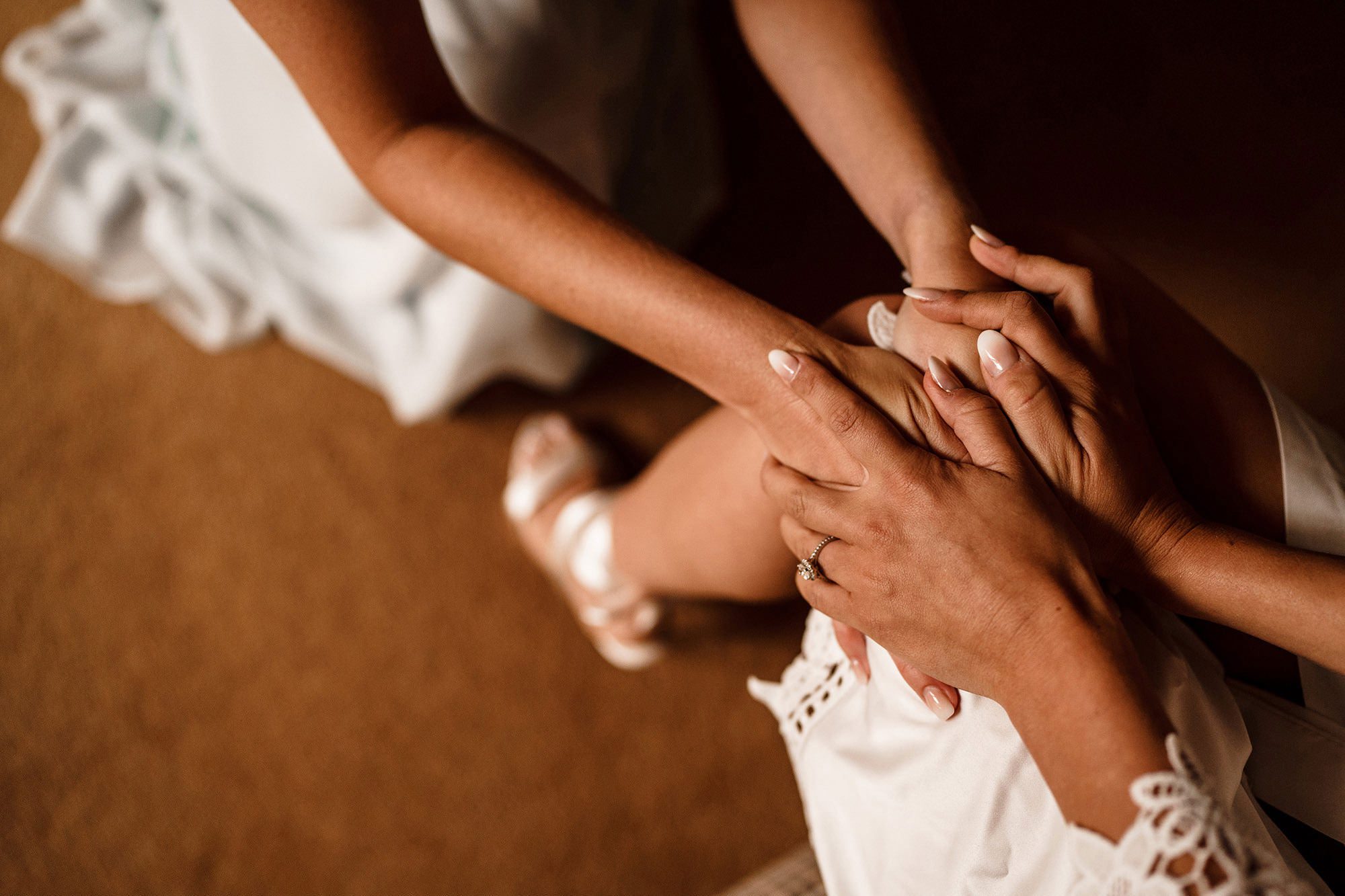 bridesmaid places hands on bride in The Cotswolds