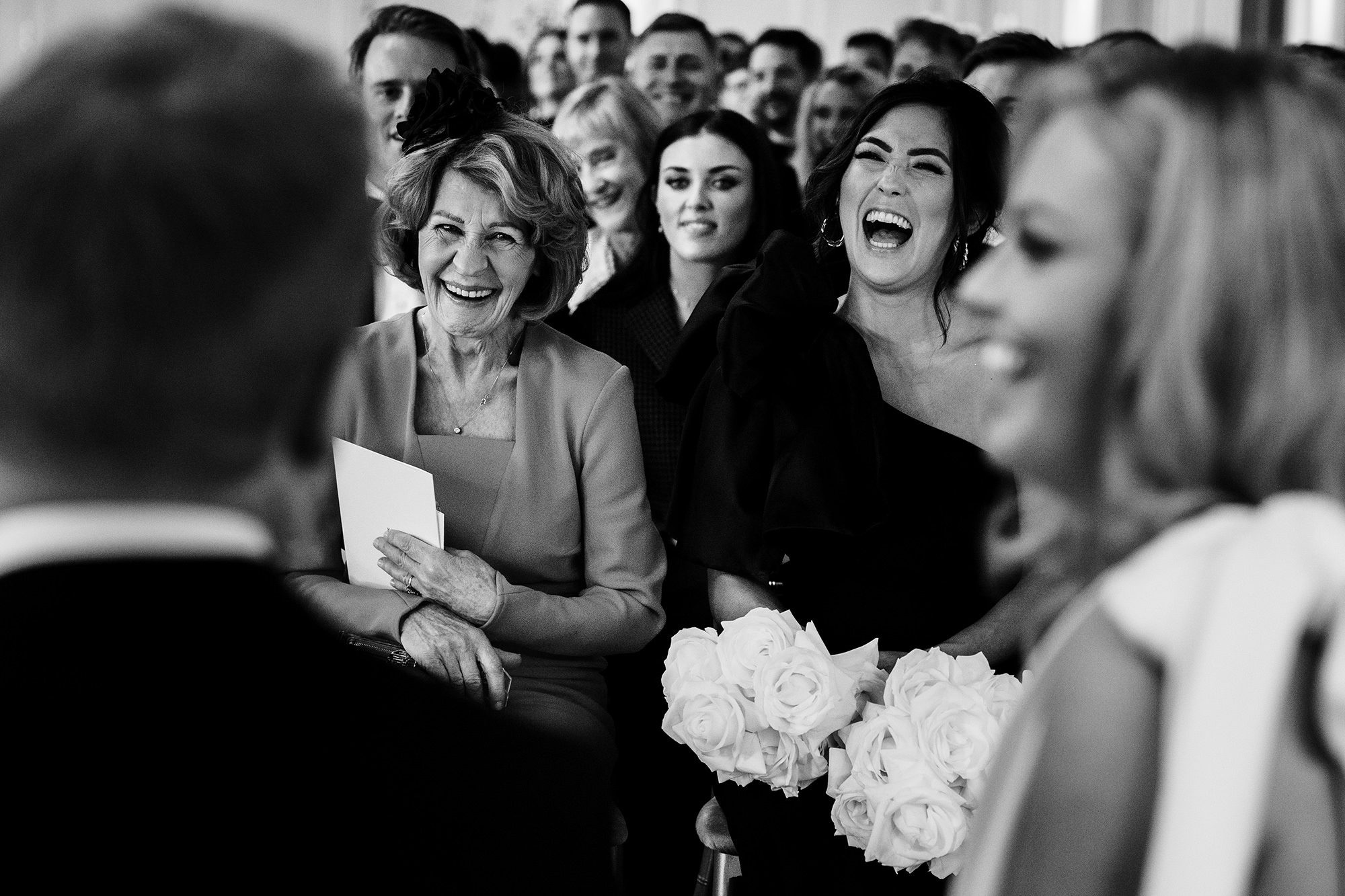 wedding guests laughing at a wedding ceremony in The Cotswolds