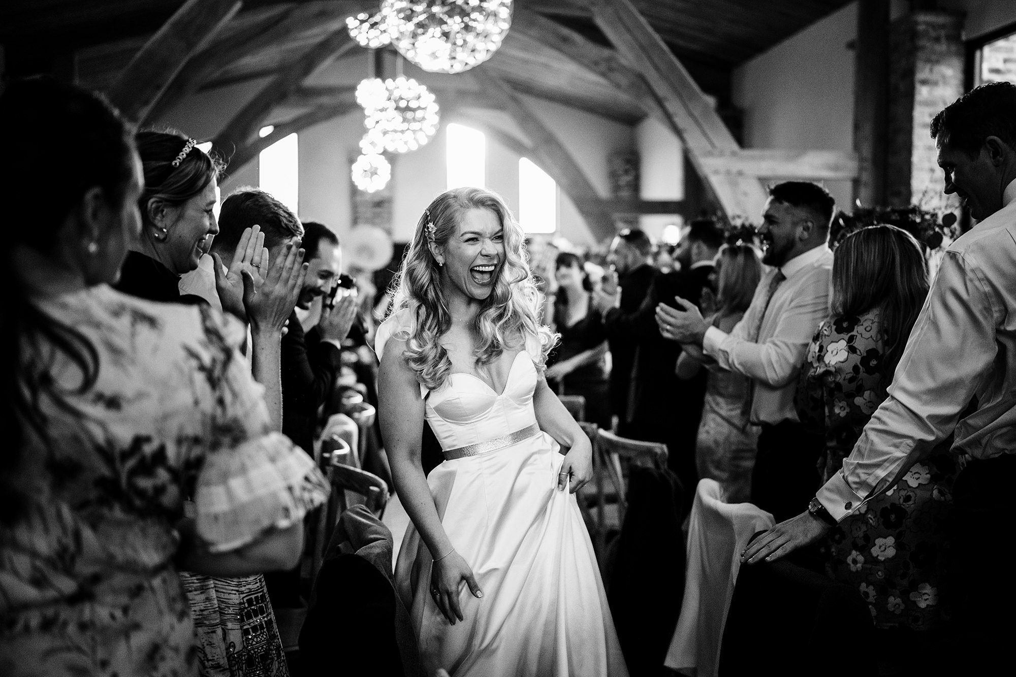 bride walks though her wedding guests at a Cotswolds wedding venue