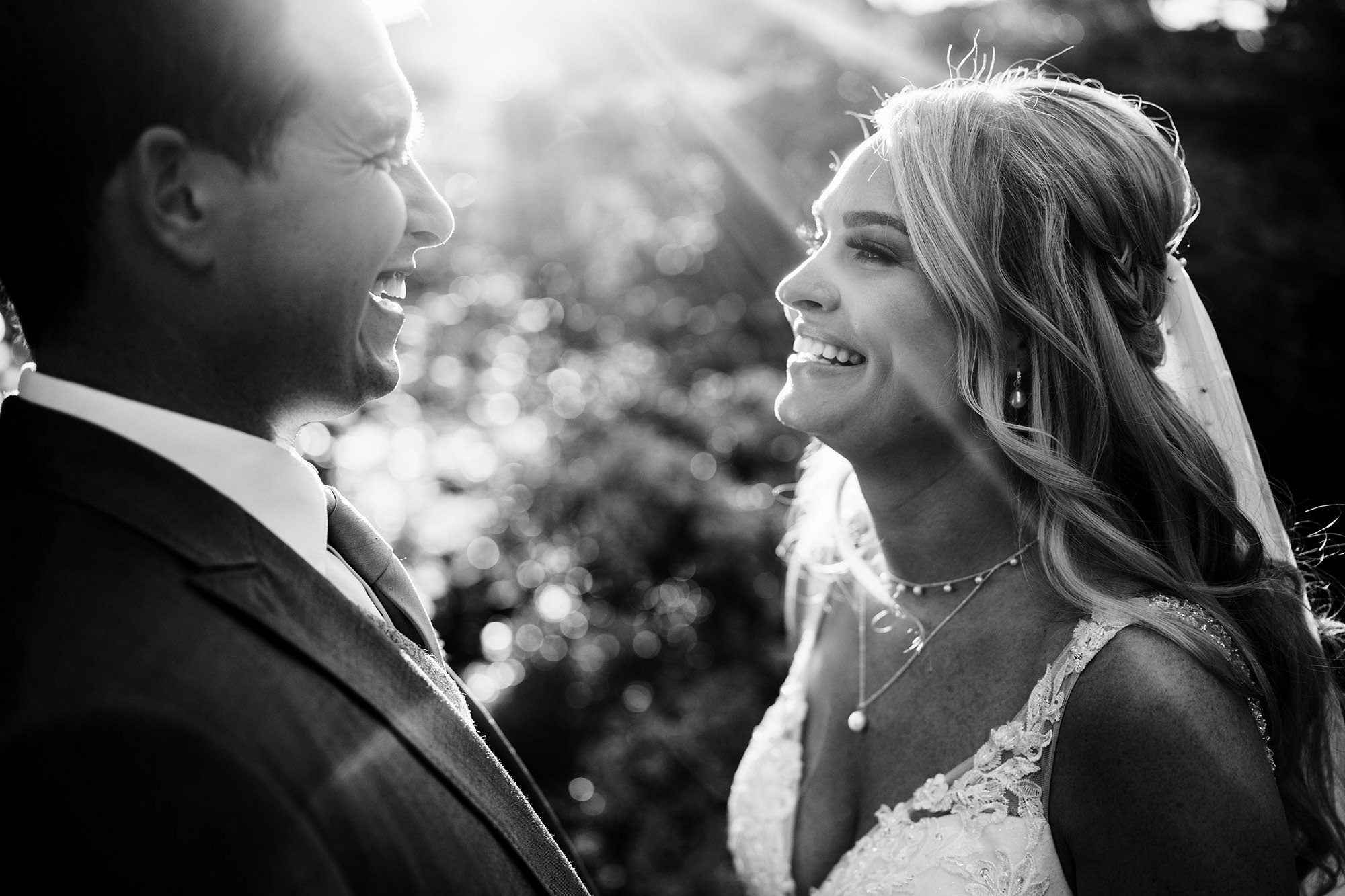backlit couple smile for photo in the lakes
